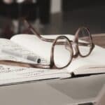 Glasses notebook and laptop, eyeglasses with gray frames on the top of notebook