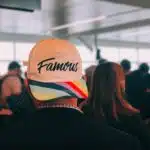 , man wearing multicolored Famous cap