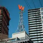 , a tall building with a red sign on top of it