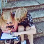 , boy and girl answering questions on white paper